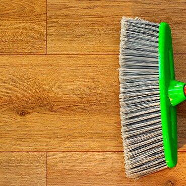 Cleaning wooden floor with broom | Haight Carpet & Interior